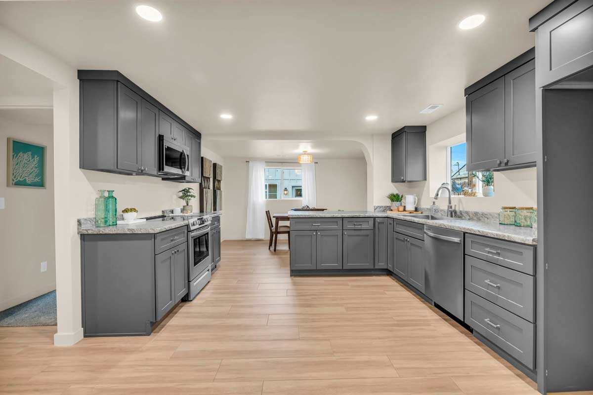 A modern kitchen featuring gray cabinets and elegant hardwood floors, creating a stylish and inviting atmosphere.