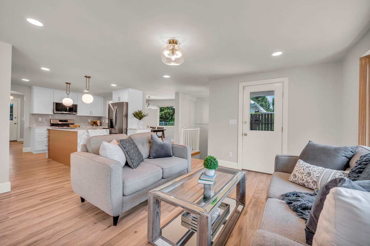 A modern living room featuring gray furniture and polished hardwood floors, exuding a clean and inviting atmosphere.