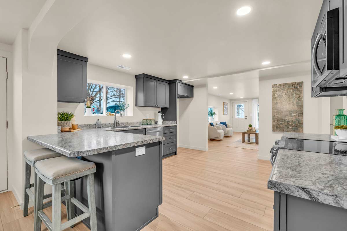 A modern kitchen featuring gray cabinets and a sleek marble countertop, showcasing a stylish and contemporary design.