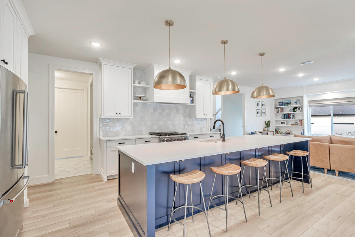 15-baier-residence-new-build A sophisticated kitchen featuring elegant blue and white cabinets, complemented by a stylish bar area for entertaining.