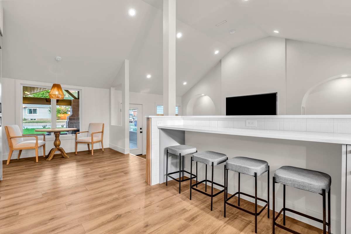 A modern kitchen featuring a bar area and a cozy dining space, designed for both cooking and entertaining.