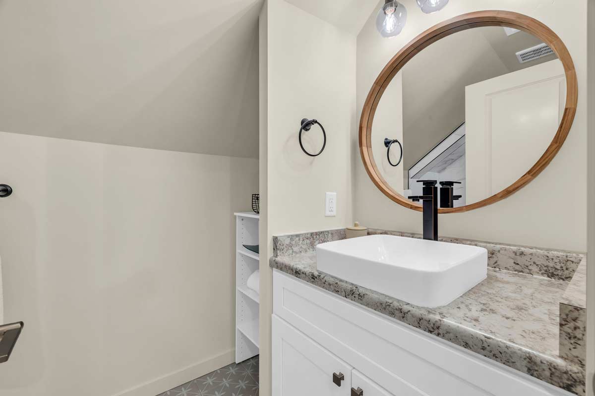 A clean bathroom featuring a sink, a mirror above it, and a toilet, all arranged in a modern design.