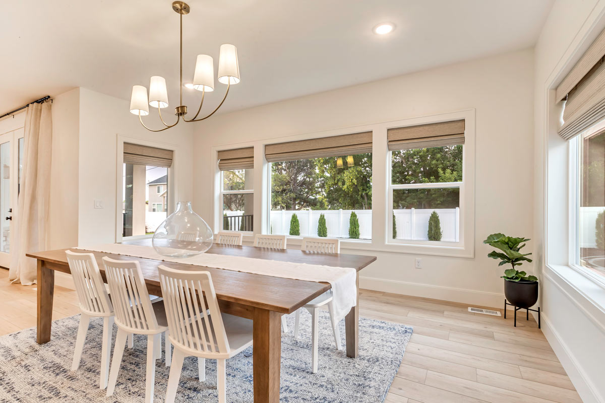 22-baier-residence-new-build Elegant dining room featuring pristine white chairs surrounding a sophisticated table, exuding a sense of luxury and style.