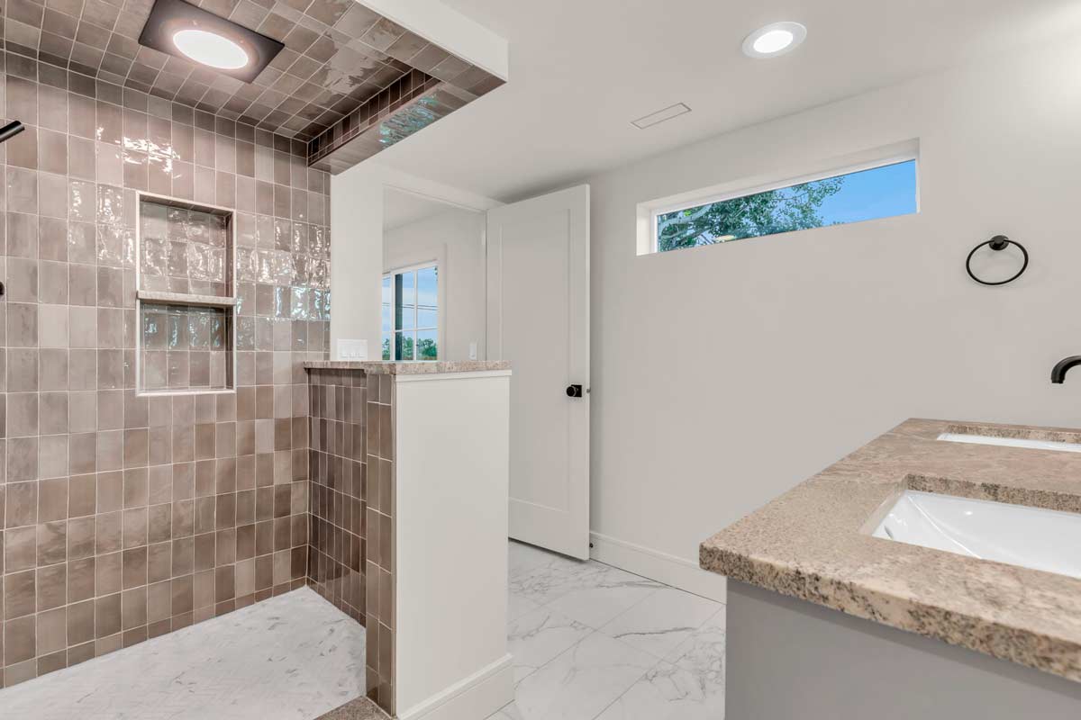 A clean bathroom featuring a modern shower and a sleek sink, designed for functionality and comfort.