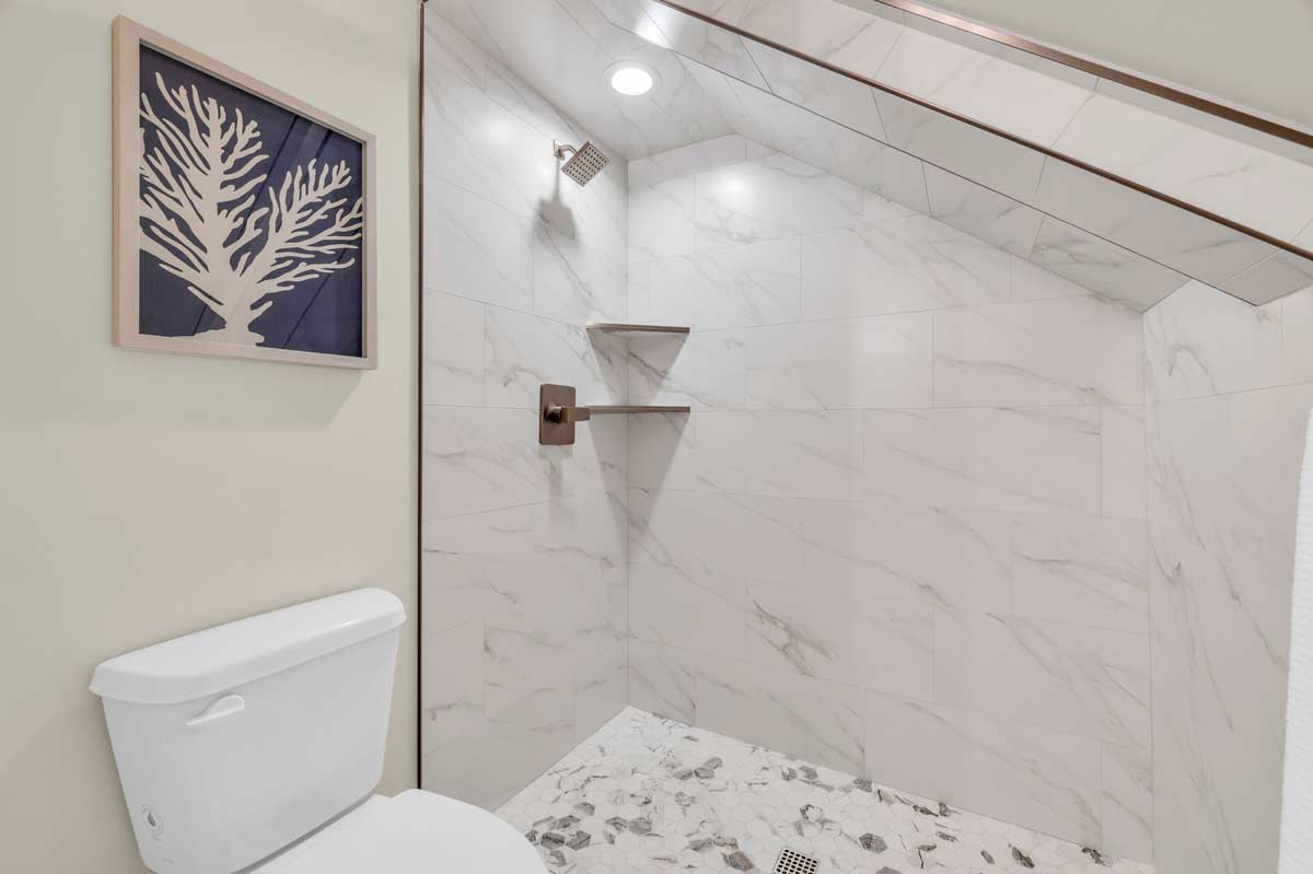 A modern bathroom featuring a sleek marble floor and a pristine white toilet, showcasing elegant design and cleanliness.