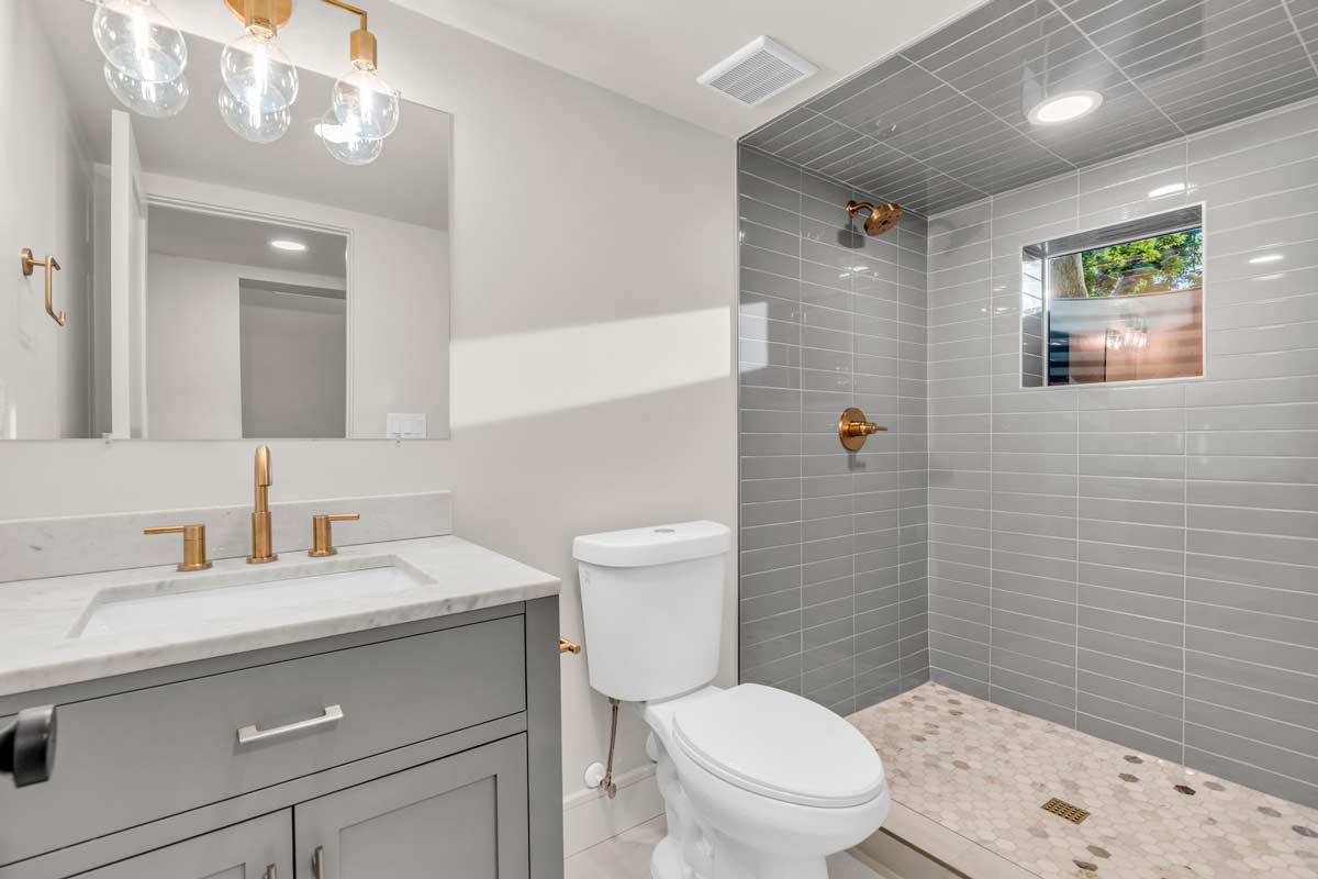 A clean bathroom featuring a shower, toilet, and sink, designed for functionality and comfort.
