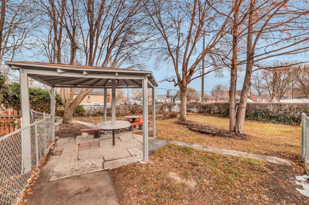A serene backyard featuring a picnic table under a gazebo, perfect for outdoor gatherings and relaxation.