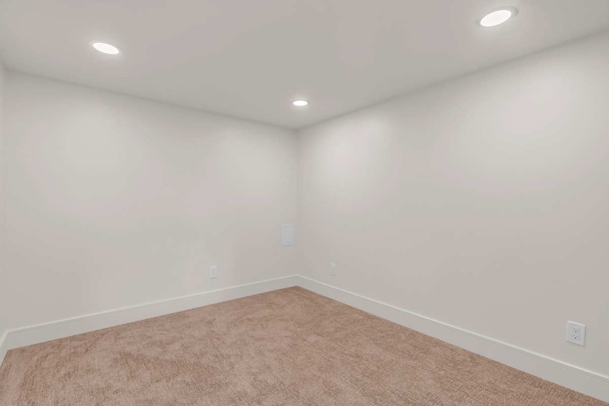 An empty room featuring a carpeted floor and pristine white walls, creating a spacious and minimalist atmosphere.