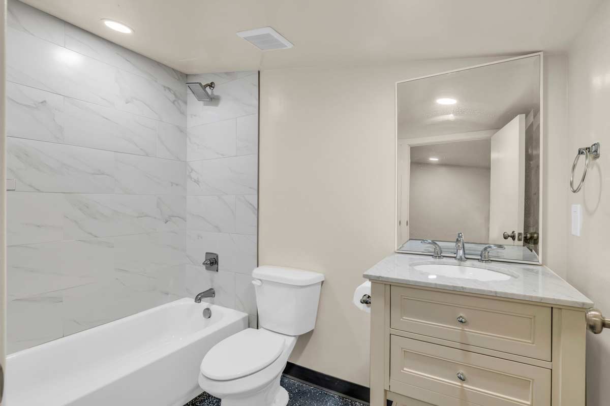 A clean bathroom featuring a white toilet and sink, emphasizing a minimalist and modern design.