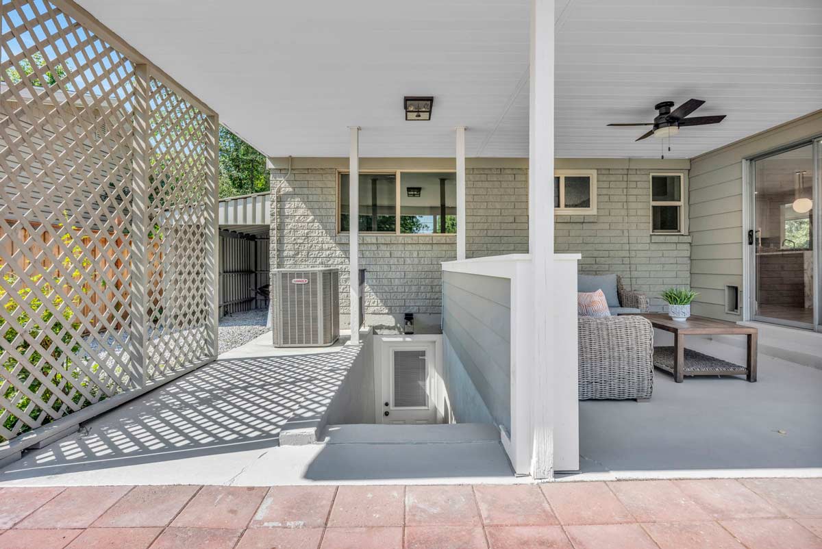 A serene patio featuring a white fence and stylish patio furniture, perfect for outdoor relaxation and gatherings.