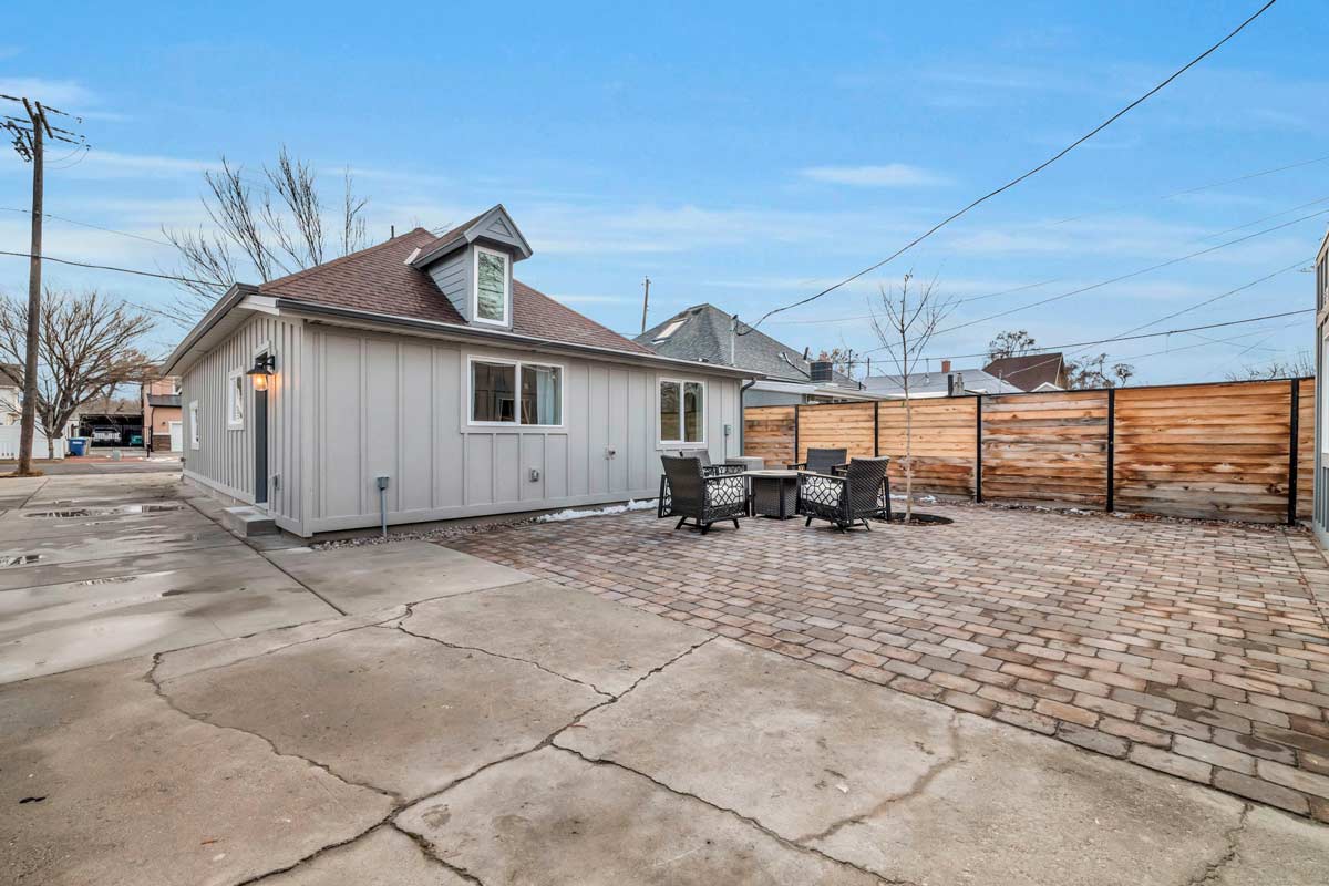 A serene backyard featuring a stylish patio surrounded by an elegant fence, perfect for relaxation and outdoor gatherings.