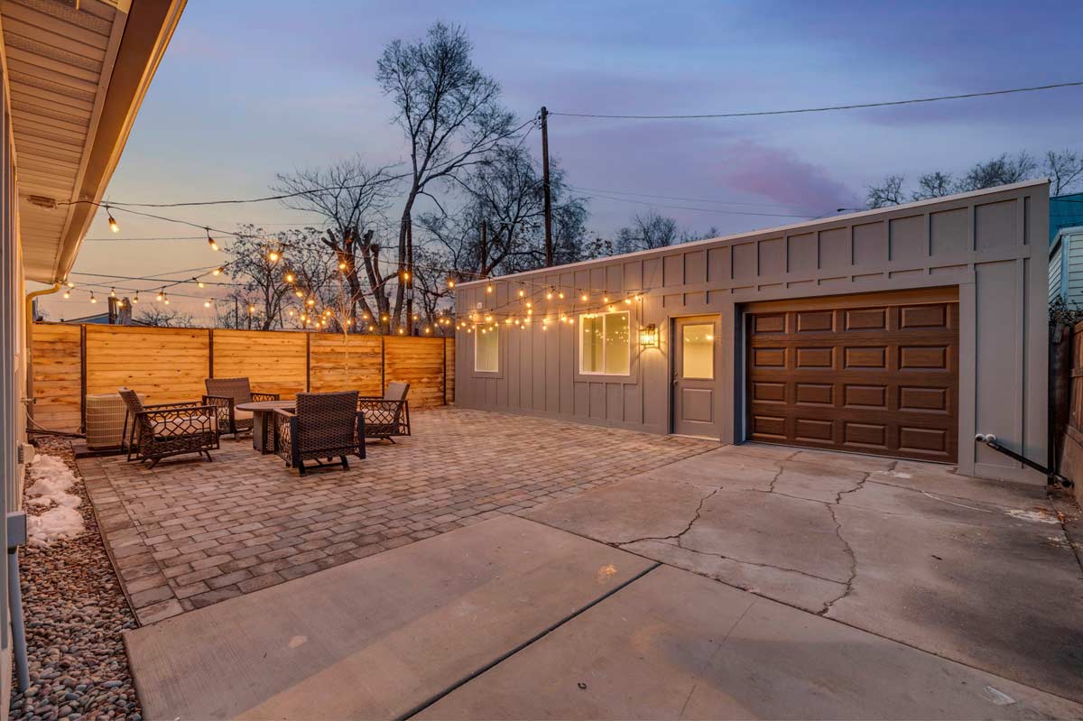 A serene backyard adorned with elegant patio furniture and twinkling lights, creating a perfect ambiance for relaxation.