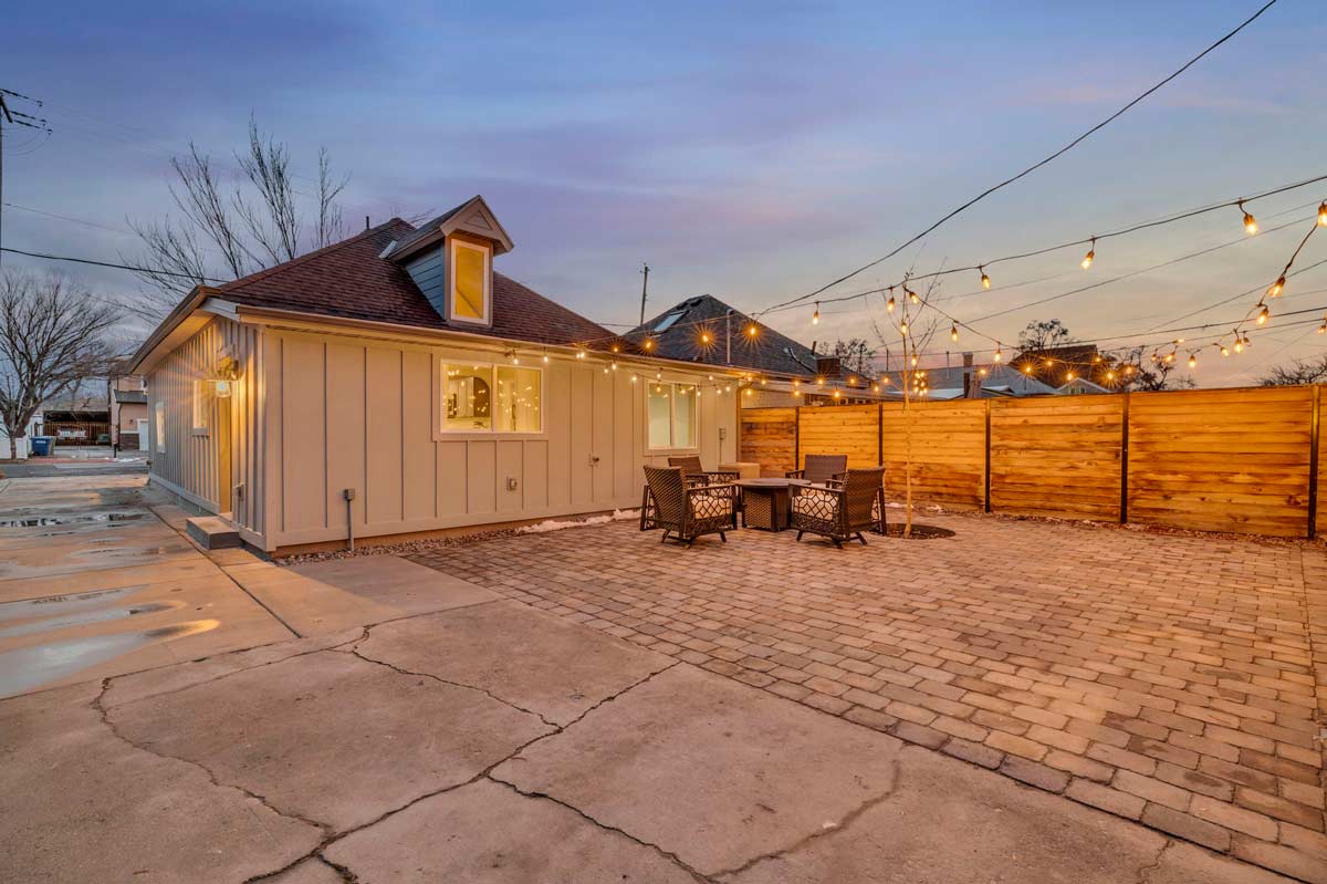 A serene backyard featuring a stylish patio and a sleek grill, perfect for outdoor gatherings and culinary delights.