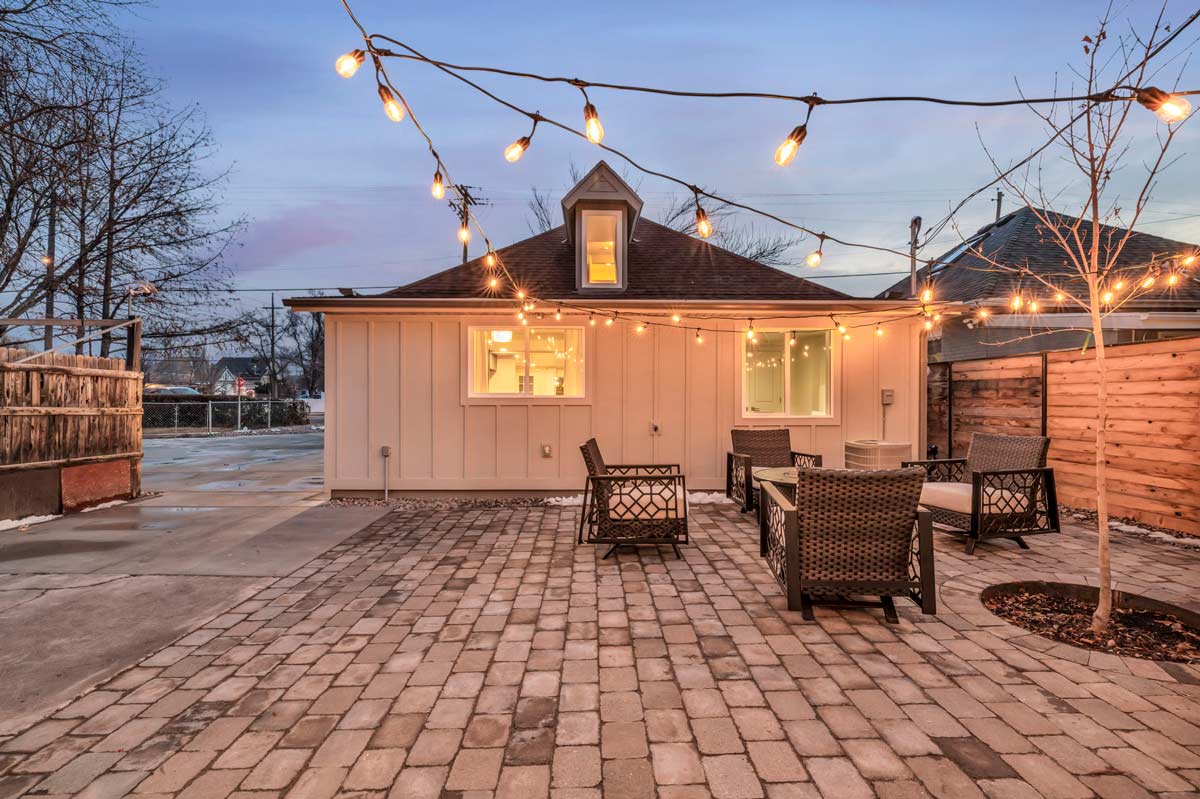 A charming backyard adorned with elegant patio furniture and twinkling string lights, perfect for serene evenings.