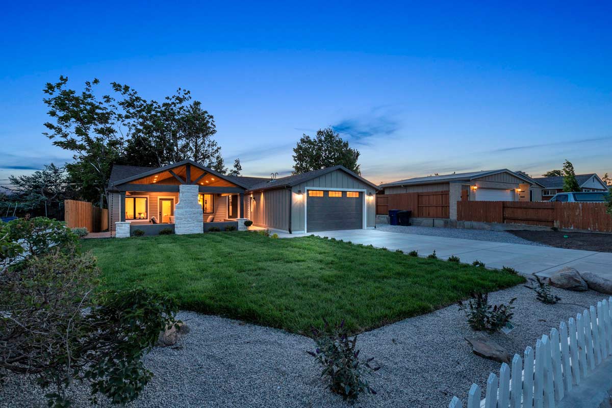 A luxurious home featuring an elegant driveway and a beautifully designed fence, exuding sophistication and charm.