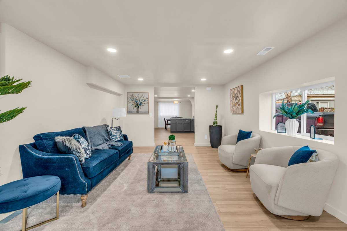 A cozy living room featuring blue couches arranged around a stylish coffee table.