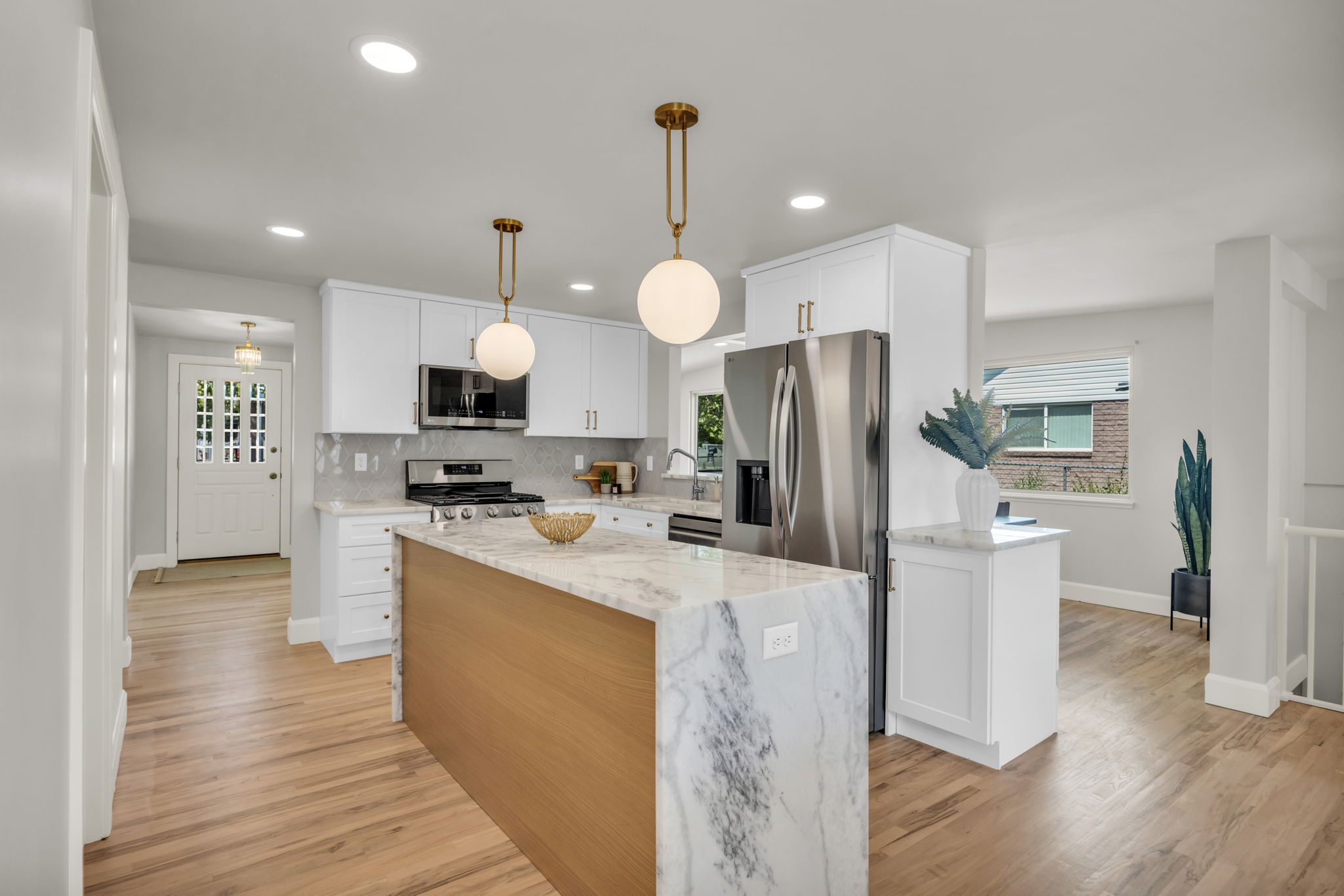 A modern kitchen featuring stainless steel appliances and elegant marble countertops, showcasing a sleek and stylish design.