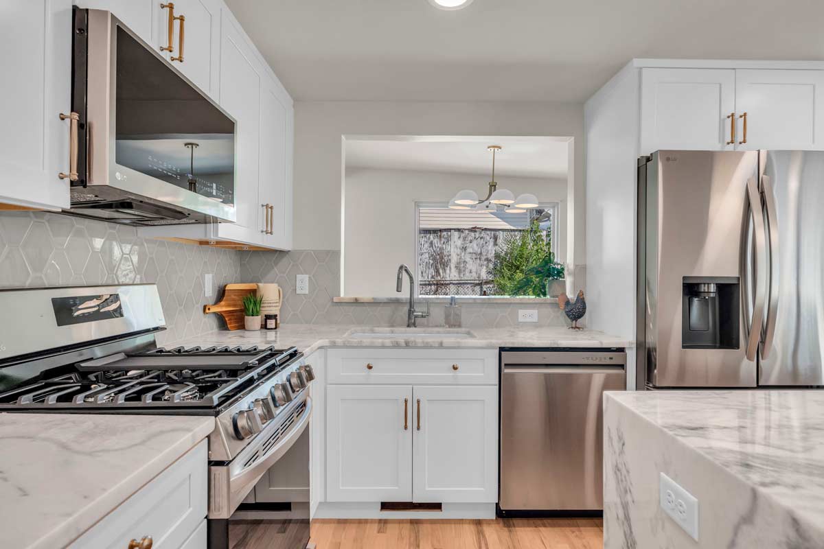 A modern kitchen featuring stainless steel appliances and elegant marble countertops, showcasing a sleek and stylish design.