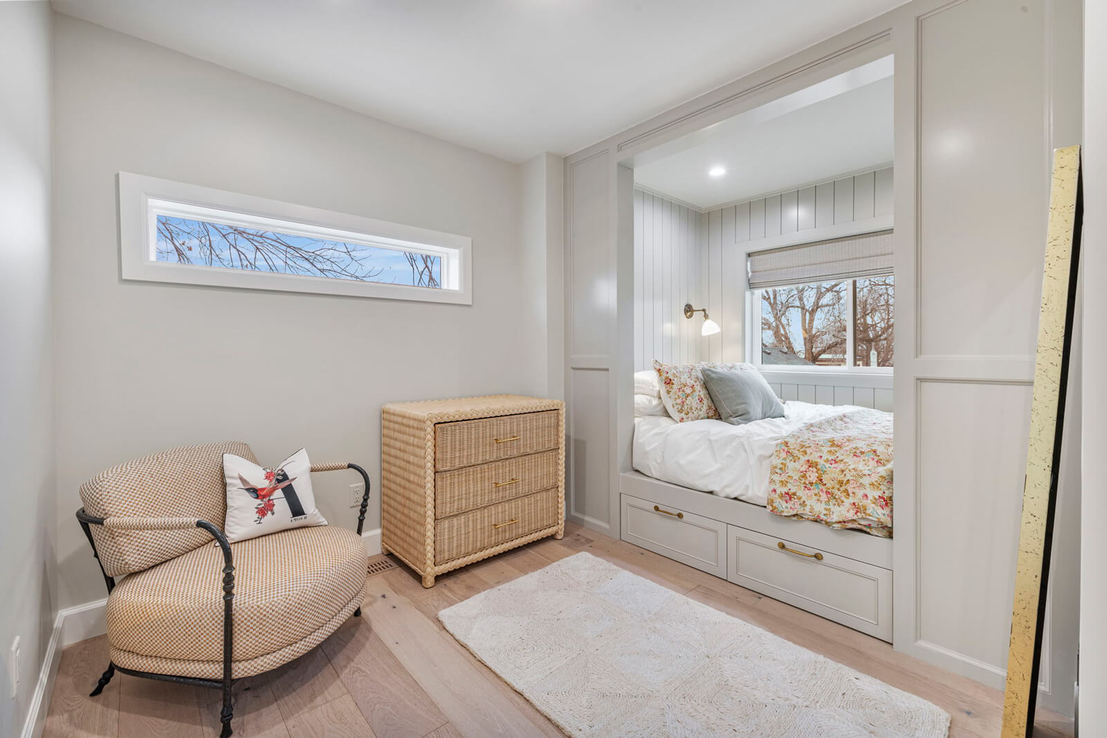A cozy bedroom featuring a neatly made bed and a stylish mirror reflecting the serene atmosphere of the room.