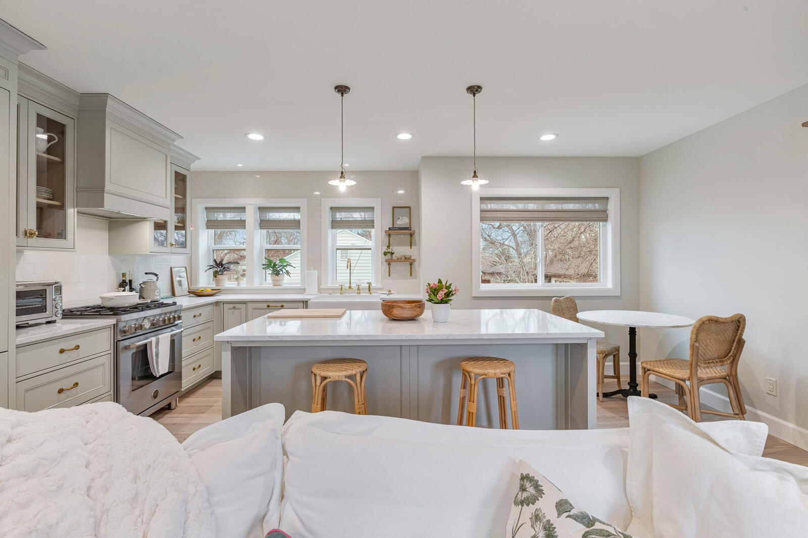 A modern kitchen featuring a white countertop and a white couch, creating a bright and inviting atmosphere.