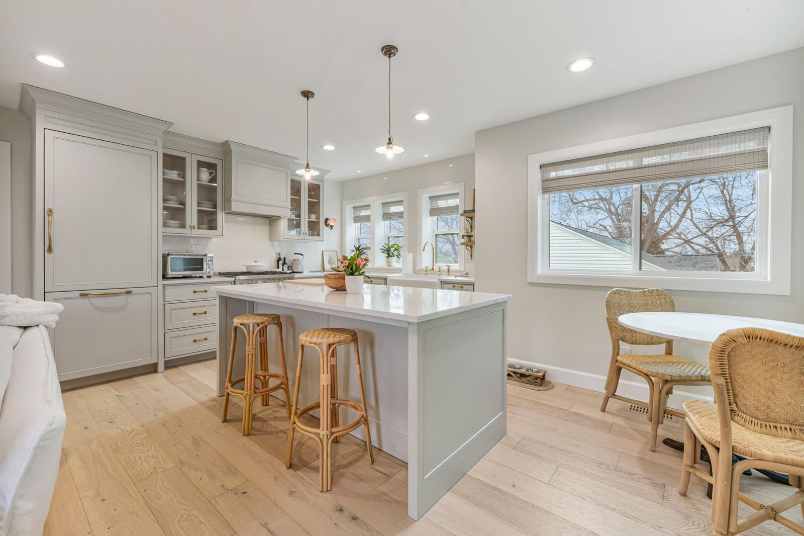 A modern kitchen featuring a white couch and stylish bar stools, creating a cozy and inviting atmosphere.