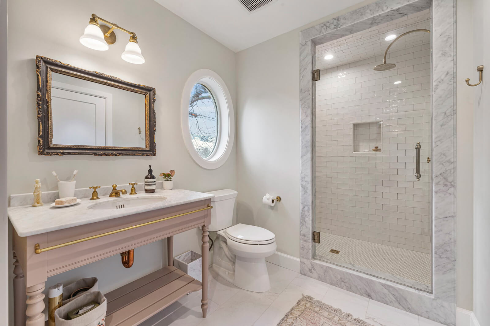 A bathroom featuring a round window and a modern sink, showcasing a blend of natural light and contemporary design.