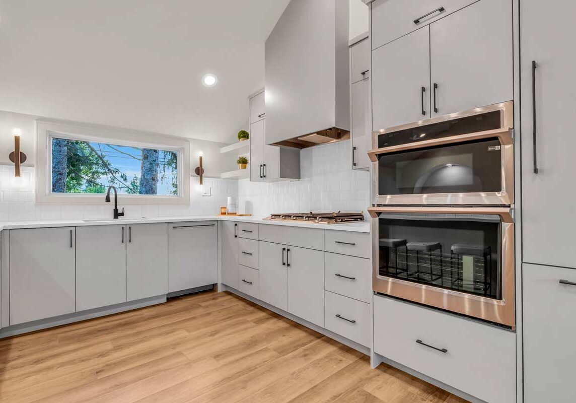 A sophisticated kitchen featuring elegant white cabinets and warm wood floors, exuding timeless charm and luxury.