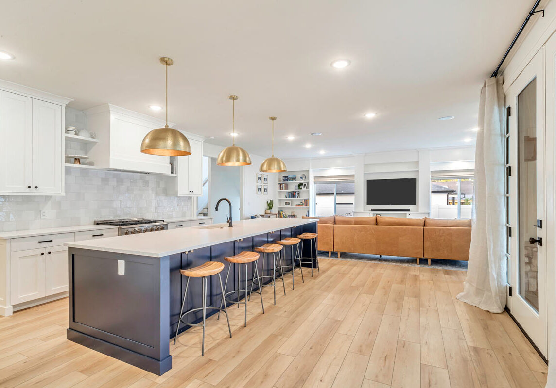 A luxurious kitchen featuring a spacious center island and elegant wooden floors, exuding warmth and sophistication.