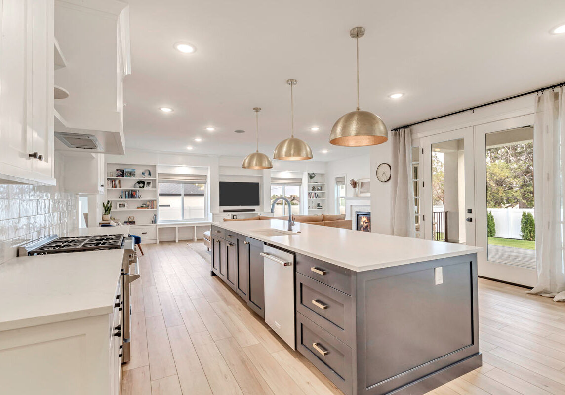 A sophisticated kitchen featuring elegant white cabinets and warm wooden floors, exuding a timeless charm and luxury.