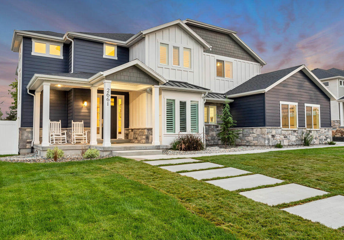 Front exterior of the Baier residence at dusk, highlighting the warm, inviting glow from the windows and the striking modern architecture.