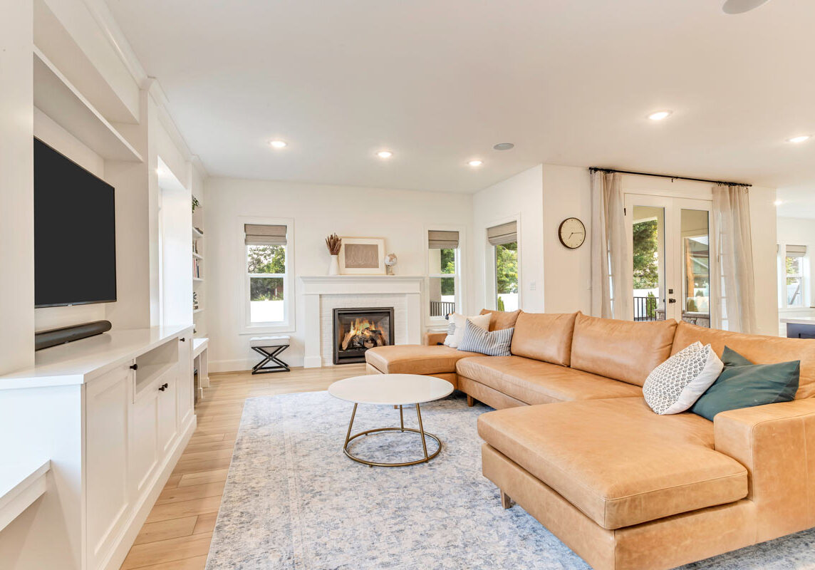 A luxurious living room featuring an elegant couch, a stylish coffee table, and a warm, inviting fireplace.