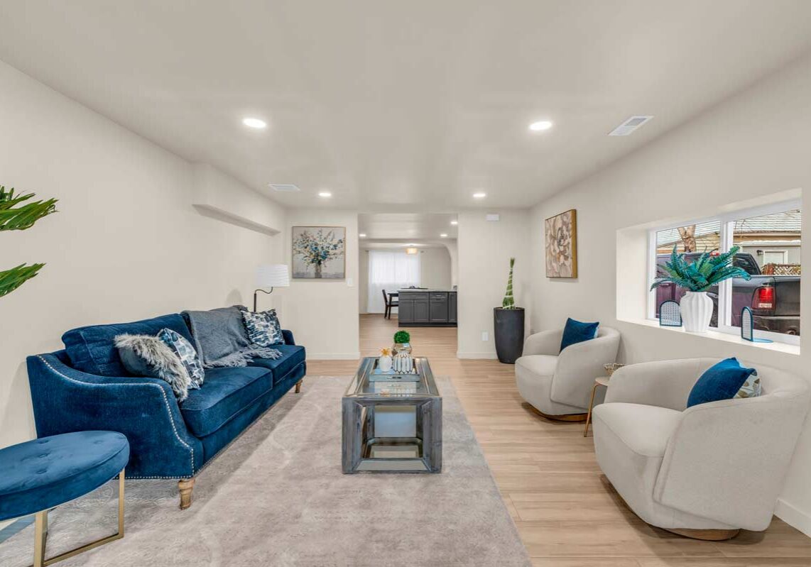 A cozy living room featuring blue couches arranged around a stylish coffee table.