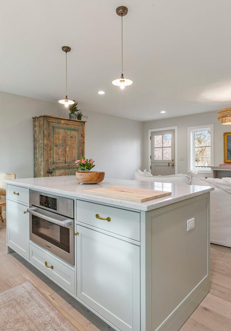 benson-adu-project-island-counter A modern kitchen featuring a white island and elegant wooden floors, creating a warm and inviting atmosphere.